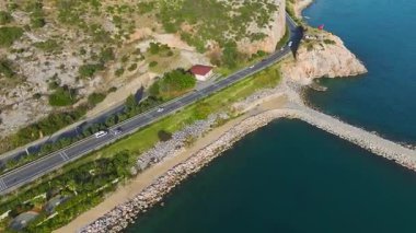 Şehrin panoramik deniz manzaralı, kayalıklı ve canlı şehir manzaralı sembol.