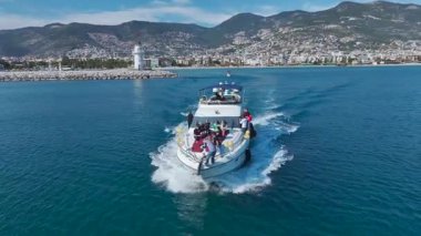 Bir grup insan derin mavi denizde yatta rahatlıyor ve kutlama yapıyorlar..