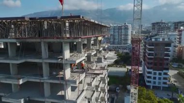 Çelik ve beton iskelet üzerinde tahta yerleştiren işçilerin yakın çekim görüntüleri.
