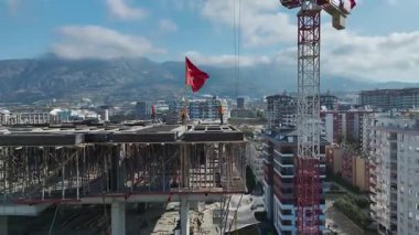 Çalışan işçilerin yakın çekim görüntüsü, yukarıda vinç, arkada ufuk çizgisi ve mavi ufuk..