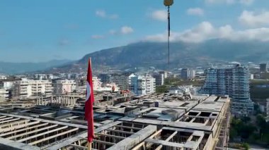 Miğferli işçilerin inşaat malzemelerini büyük yükseklikte kullanışlarının insansız görüntüsü.