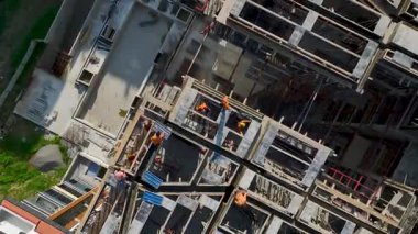 İnşaat ekibinin beton kalıpları monte ederken tepeden tırnağa dron görüntüsü.