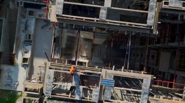 İnşaat alanının iskeletinin üzerinde asılı duran vincin İHA görüntüsünü kapat.