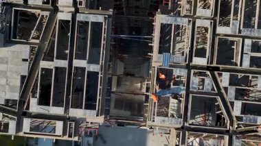 Drone, işçilerin kıyı şehrinin yukarısındaki panelleri istiflediğini ve kirişleri koruduğunu gösteriyor..