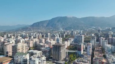 İnsansız hava aracı, şehir bloklarıyla çevrili, bitmemiş yüksek binaların üzerinde çalışan uzun vinci yakalıyor..