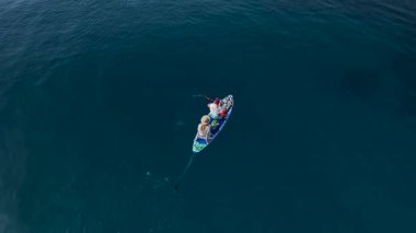 Kayalar ve dağlar arasında süzülerek süzülen kürekçiler.