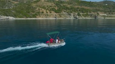 Çocuklar ve yetişkinler sakin denizin tadını çıkarıyorlar..