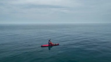 SUP sürücüleri kıyı şeridi yakınlarındaki cam sularda süzülüyorlar.