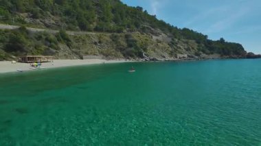 Kayalık kıyı şeridinde sürüklenen tahtalar grubu.