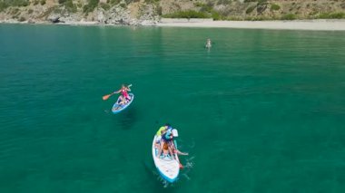 Turkuaz dalgalara yakın yüzen arkadaşlar.