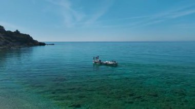İnsansız hava aracı, turkuaz yeşil suyun yakınında bir gemi yakalıyor..