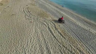 Su kenarında yarışan ATV, kumsalda görünen plaj izleri..