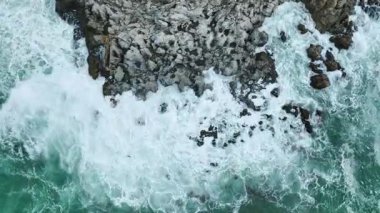 Kayalıklara çarpan su enerjisinin drone görüntüsü.