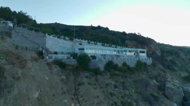 Kemerli cam kapıları olan kayalıklardaki taş villa..