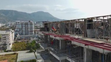 İşçi tamamlanmamış beton kulede duruyor.