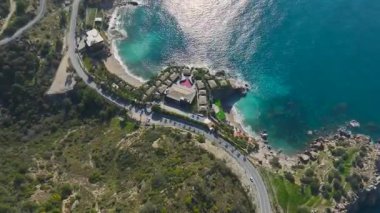 Kayalık kayalıkları ve kumlu plajları olan bir otel sahili..