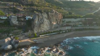 Köpüklü dalgalar taşlara çarpar.