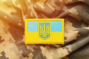 Ukrayna bayrağıyla pikselleştirilmiş dijital askeri kamuflaj kumaşı ve mavi ve sarı renkli sembollü arma. Ukrayna asker üniformasının nitelikleri
