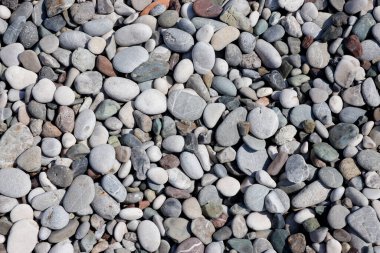 Deniz kıyısındaki kumsaldan çakıl taşlarının dokusu. Deniz kıyısından çok sayıda çakıl taşı