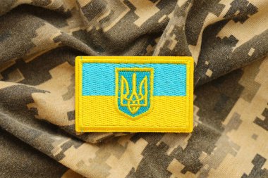 Ukrayna bayrağıyla pikselleştirilmiş dijital askeri kamuflaj kumaşı ve mavi ve sarı renkli sembollü arma. Ukrayna asker üniformasının nitelikleri
