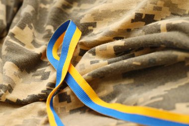 Mavi ve sarı renkli kurdeleli dijital askeri kamuflaj kumaşı. Ukraynalı vatansever asker üniformasının nitelikleri
