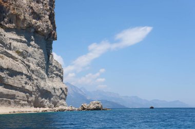 Türkiye 'de seyahat etmek Ege Denizi ve kayalık ada manzarası tabiat beldeleri güzel manzaralı tatil köyleri yaz mevsimi. Derin mavi deniz suyunun üzerinde büyük sallanan kıyılar. Serinlemek için lüks yerler