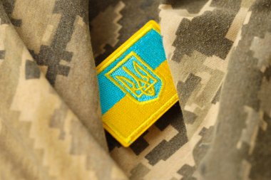 Ukrayna bayrağıyla pikselleştirilmiş dijital askeri kamuflaj kumaşı ve mavi ve sarı renkli sembollü arma. Ukrayna asker üniformasının nitelikleri