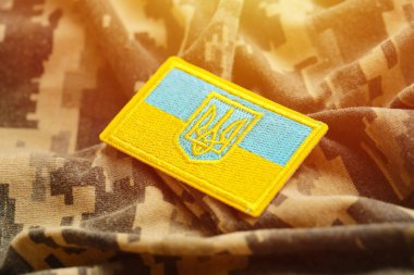 Ukrayna bayrağıyla pikselleştirilmiş dijital askeri kamuflaj kumaşı ve mavi ve sarı renkli sembollü arma. Ukrayna asker üniformasının nitelikleri