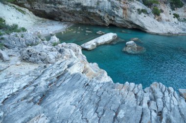 Türkiye 'de seyahat etmek Ege Denizi ve kayalık göl manzarası. Derin mavi deniz suyunun üzerinde büyük sallanan kıyılar. Serinlemek için lüks bir yer
