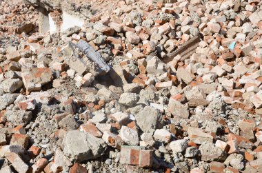 Kırık kırmızı tuğla yığını ve yıkılan binanın beton parçaları. Kırılan tuğlalar yıkıma ya da yıkıma yakın. Yapı enkazı