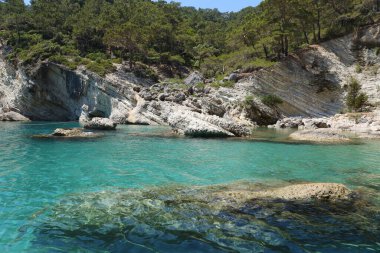 Türkiye 'de seyahat etmek Ege Denizi ve kayalık ada manzarası tabiat beldeleri güzel manzaralı tatil köyleri yaz mevsimi. Derin mavi deniz suyunun üzerinde büyük sallanan kıyılar. Serinlemek için lüks yerler