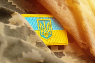 Ukrayna bayrağıyla pikselleştirilmiş dijital askeri kamuflaj kumaşı ve mavi ve sarı renkli sembollü arma. Ukrayna asker üniformasının nitelikleri