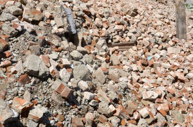 Kırık kırmızı tuğla yığını ve yıkılan binanın beton parçaları. Kırılan tuğlalar yıkıma ya da yıkıma yakın. Yapı enkazı