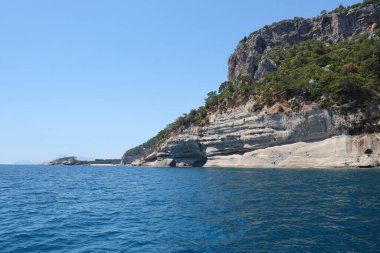 Türkiye 'de seyahat etmek Ege Denizi ve kayalık ada manzarası tabiat beldeleri güzel manzaralı tatil köyleri yaz mevsimi. Derin mavi deniz suyunun üzerinde büyük sallanan kıyılar. Serinlemek için lüks yerler