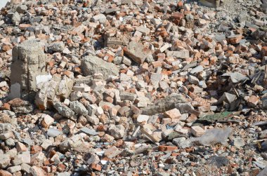 Kırık kırmızı tuğla yığını ve yıkılan binanın beton parçaları. Kırılan tuğlalar yıkıma ya da yıkıma yakın. Yapı enkazı