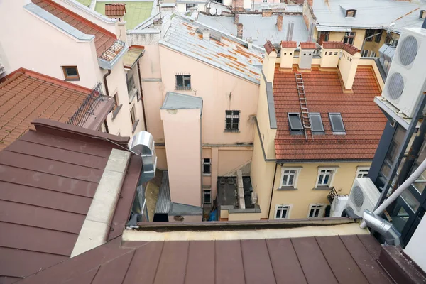 Ukrayna 'nın tarihi eski şehri Lviv' in çatılarının manzarası. Arka planda kilise kuleleri ve paslı kiremitli çatılar var.