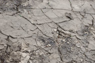 Zemin, kuraklık ve ölüm kavramına sahip arka plan veya grafik tasarımı için üst görünümde çatlaklar var.