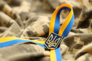 Ukrayna bayrağıyla piksellenmiş dijital askeri kamuflaj kumaşı ve çizgili şerit ve sarı renkli arma. Ukrayna asker üniformasının nitelikleri