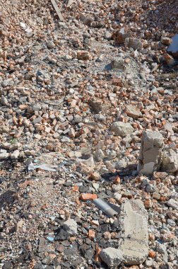 Kırık kırmızı tuğla yığını ve yıkılan binanın beton parçaları. Kırılan tuğlalar yıkıma ya da yıkıma yakın. Yapı enkazı