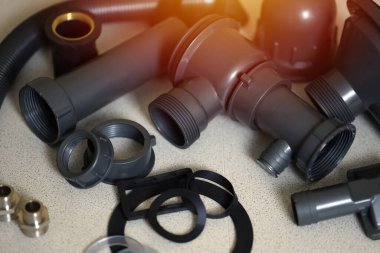 Tesisatçı aletleri ve su musluğu mutfakta lavabonun yanında kurulum için hazır. Mutfak lavabosu için musluğun kurulumu için bağlantılar