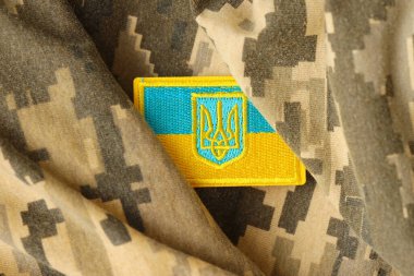 Ukrayna bayrağıyla pikselleştirilmiş dijital askeri kamuflaj kumaşı ve mavi ve sarı renkli sembollü arma. Ukrayna asker üniformasının nitelikleri