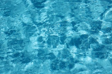 Açık havuzda mavi bir su Parlak güneş ışığının altında küçük dalgalarla
