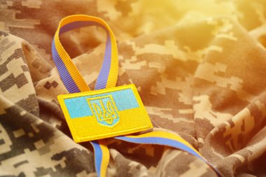 Ukrayna bayrağıyla pikselleştirilmiş dijital askeri kamuflaj kumaşı ve mavi ve sarı renkli sembollü arma. Ukrayna asker üniformasının nitelikleri