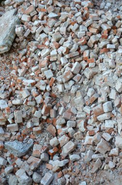 Kırık kırmızı tuğla yığını ve yıkılan binanın beton parçaları. Kırılan tuğlalar yıkıma ya da yıkıma yakın. Yapı enkazı