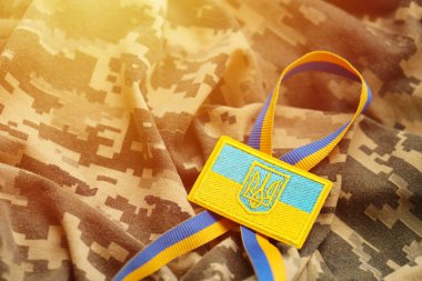 Ukrayna bayrağıyla pikselleştirilmiş dijital askeri kamuflaj kumaşı ve mavi ve sarı renkli sembollü arma. Ukrayna asker üniformasının nitelikleri
