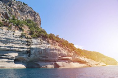 Türkiye 'de seyahat etmek Ege Denizi ve kayalık ada manzarası tabiat beldeleri güzel manzaralı tatil köyleri yaz mevsimi. Derin mavi deniz suyunun üzerinde büyük sallanan kıyılar. Serinlemek için lüks yerler