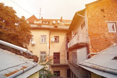 Ukrayna 'nın tarihi eski şehri Lviv' in çatılarının manzarası. Arka planda kilise kuleleri ve paslı kiremitli çatılar var.