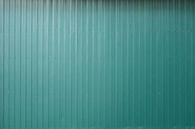 Siding metal vertical panels texture closeup in the daytime outdoors. Metal wall or fence embossed metal sheets. Terrain and large metal sheet as a barrier or fence clipart