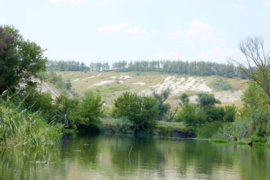 Dünya 'nın bozkırlarındaki milyonlarca tebeşir dağı. Nehir ve yeşil ağaçlarla kaplı beyaz tebeşir dağları