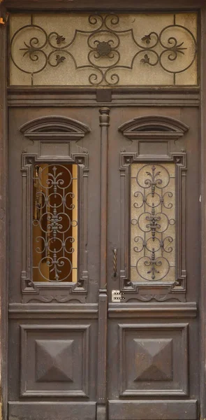ヨーロッパの中世のスタイルで古い古代の木製のドアのテクスチャ 天気予報やステンドグラスの木製の板や板から閉鎖茶色の歳のドアの詳細な質感 — ストック写真
